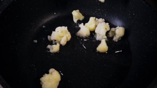 Σωστή διατροφή, χορτοφαγία. Κάτοψη του ψημένου κουνουπιδιού στο τηγάνι. Κοντινό πλάνο. Αργή κίνηση — Αρχείο Βίντεο
