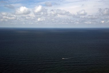 Bulutlardan küçük bir yatla gelen deniz manzarası..