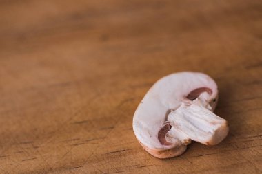 Mantar kesimi ön plandaki ahşap masaya yakın.