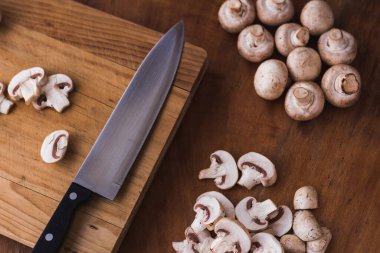 Kesme tahtasında bıçakla doğranmış mantar.