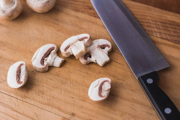 sliced mushroom on chopping board with a knife