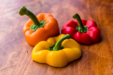 Tahta bir masada dilimlenmiş portakal, kırmızı ve sarı dolma biber.
