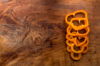 Tahta masada dilimlenmiş portakal dolma biber.