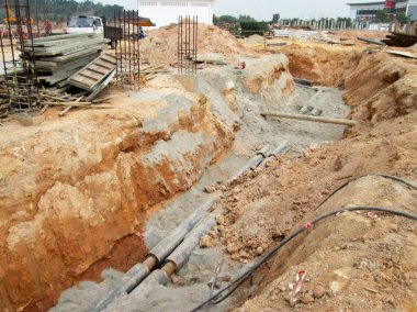 Kuala Lumpur, Malezya-02 Haziran 2017: yeraltı yardımcı programı ve Hizmetleri boru koydu işçiler inşaat sahasında siperlerde tarafından. Cork vanasını ve devam eden ortak kurulumu.   