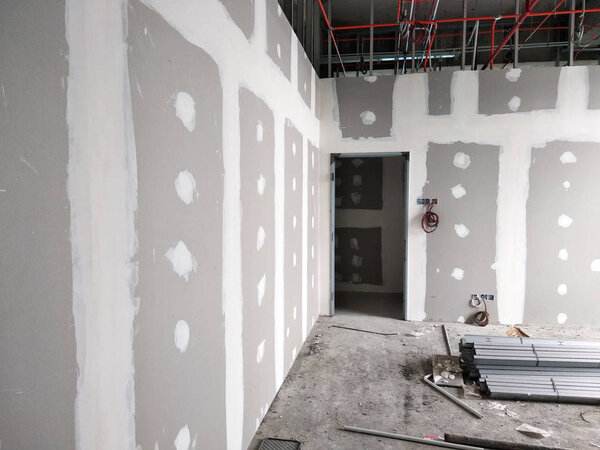 KUALA LUMPUR, MALAYSIA -APRIL 12, 2018: Drywall installation work in progress by construction workers at the construction site. It is the easiest and cheapest way to do partition for the interior wall. 