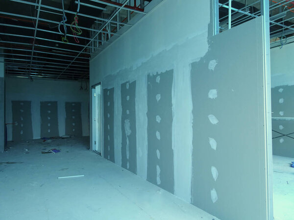 KUALA LUMPUR, MALAYSIA -APRIL 12, 2018: Drywall installation work in progress by construction workers at the construction site. It is the easiest and cheapest way to do partition for an interior wall. 