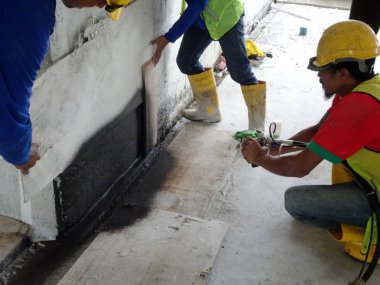 Kuala Lumpur, Malezya-25 Mayıs 2018: Betonarme döşeme üzerine inşaat işçileri tarafından uygulanan mambrane su yalıtımı. Su betonarme döşeme altına girmesini önlemek için su yalıtım katmanı.   