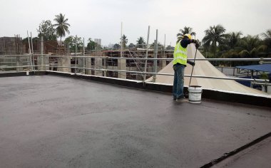 Kuala Lumpur, Malezya-25 Mayıs 2018: Betonarme döşeme üzerine inşaat işçileri tarafından uygulanan mambrane su yalıtımı. Su betonarme döşeme altına girmesini önlemek için su yalıtım katmanı.   