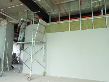 Kuala Lumpur, Malezya-12 Nisan 2018: Drywall yükleme yapım aşamasında şantiyede inşaat işçileri tarafından. Bölüm için bir iç duvar yapmanın en kolay ve en ucuz yolu olduğunu. 