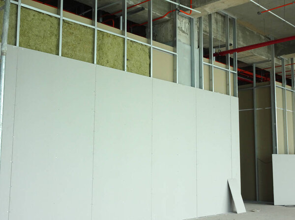 KUALA LUMPUR, MALAYSIA -APRIL 12, 2018: Drywall installation work in progress by construction workers at the construction site. It is the easiest and cheapest way to do partition for an interior wall. 