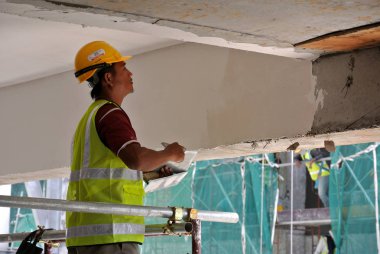 Kuala Lumpur, Malezya-06 Nisan 2017: inşaat site işçileri tavan recessed yağsız kat işini inşaat sahasında yapıyorsunuz. İki katmanlar temel ve son kat uygulayın düzgün yüzey elde etmek için. 