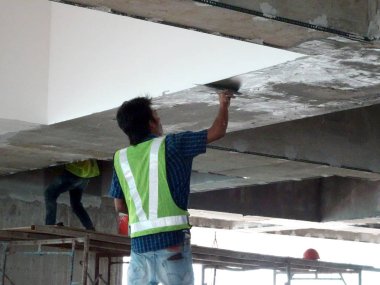 Kuala Lumpur, Malezya-06 Nisan 2017: inşaat site işçileri tavan recessed yağsız kat işini inşaat sahasında yapıyorsunuz. İki katmanlar temel ve son kat uygulayın düzgün yüzey elde etmek için. 