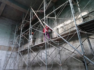 Kuala Lumpur, Malezya-23 Temmuz 2018: inşaat işçileri çimento kullanarak duvar sıvama alçı inşaat alanında. Onlar kötü olmasını önlemek için uygun güvenlik dişli giyiyorsun.  