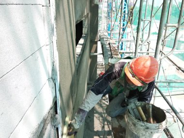 Kuala Lumpur, Malezya-23 Temmuz 2018: inşaat işçileri çimento kullanarak duvar sıvama alçı inşaat alanında. Onlar kötü olmasını önlemek için uygun güvenlik dişli giyiyorsun.  