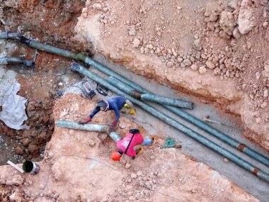 Kuala Lumpur, Malezya-02 Haziran 2017: inşaat alanında sığ siperlerde yeraltı yardımcı ve hizmet boru yükleme Işçiler. Kaynak yöntemi kullanılarak boru eklem montajı.    