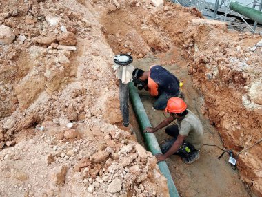 Kuala Lumpur, Malezya-Temmuz 31, 2018: yeraltı yarar ve hizmetler boru inşaat alanında siperlerde işçiler tarafından koydu. Boru eklem ve dirsek montajı devam ediyor. 