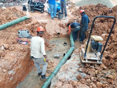 Kuala Lumpur, Malezya-Temmuz 31, 2018: yeraltı yarar ve hizmetler boru inşaat alanında siperlerde işçiler tarafından koydu. Boru eklem ve dirsek montajı devam ediyor. 