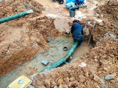 Kuala Lumpur, Malezya-Temmuz 31, 2018: yeraltı yarar ve hizmetler boru inşaat alanında siperlerde işçiler tarafından koydu. Boru eklem ve dirsek montajı devam ediyor. 