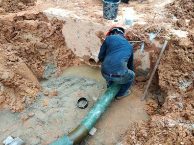Kuala Lumpur, Malezya-Temmuz 31, 2018: yeraltı yarar ve hizmetler boru inşaat alanında siperlerde işçiler tarafından koydu. Boru eklem ve dirsek montajı devam ediyor. 