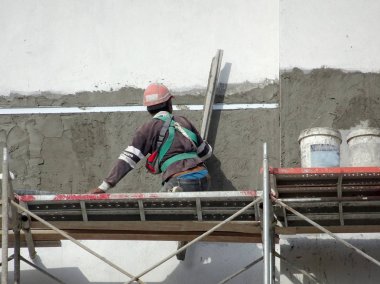 Kuala Lumpur, Malezya-23 Temmuz 2018: inşaat işçileri çimento kullanarak duvar sıvama alçı inşaat alanında. Onlar kötü olmasını önlemek için uygun güvenlik dişli giyiyorsun. 