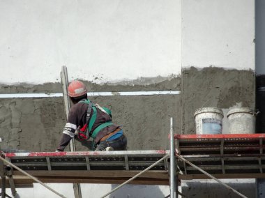 Kuala Lumpur, Malezya-23 Temmuz 2018: inşaat işçileri çimento kullanarak duvar sıvama alçı inşaat alanında. Onlar kötü olmasını önlemek için uygun güvenlik dişli giyiyorsun. 