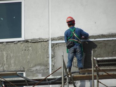 Kuala Lumpur, Malezya-23 Temmuz 2018: inşaat işçileri çimento kullanarak duvar sıvama alçı inşaat alanında. Onlar kötü olmasını önlemek için uygun güvenlik dişli giyiyorsun. 