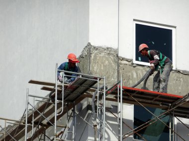 Kuala Lumpur, Malezya-23 Temmuz 2018: inşaat işçileri çimento kullanarak duvar sıvama alçı inşaat alanında. Onlar kötü olmasını önlemek için uygun güvenlik dişli giyiyorsun. 