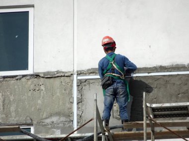 Kuala Lumpur, Malezya-23 Temmuz 2018: inşaat işçileri çimento kullanarak duvar sıvama alçı inşaat alanında. Onlar kötü olmasını önlemek için uygun güvenlik dişli giyiyorsun. 