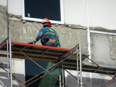Kuala Lumpur, Malezya-23 Temmuz 2018: inşaat işçileri çimento kullanarak duvar sıvama alçı inşaat alanında. Onlar kötü olmasını önlemek için uygun güvenlik dişli giyiyorsun. 