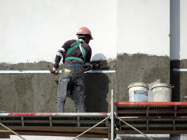 Kuala Lumpur, Malezya-23 Temmuz 2018: inşaat işçileri çimento kullanarak duvar sıvama alçı inşaat alanında. Onlar kötü olmasını önlemek için uygun güvenlik dişli giyiyorsun. 