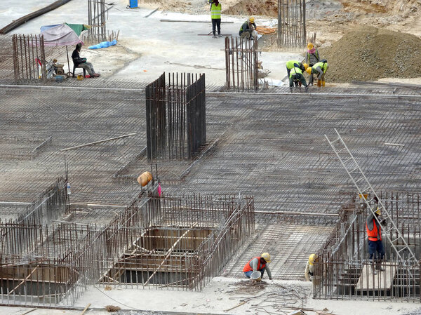 KUALA LUMPUR, MALAYSIA -APRIL 13, 2018: Construction workers installing reinforcement bar at the construction site. Reinforcement bar is the main component for the reinforcement concrete.   