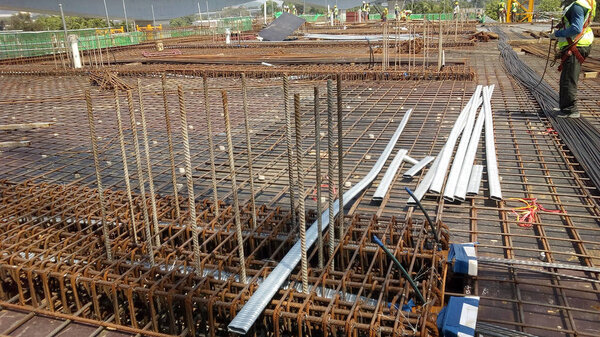 KUALA LUMPUR, MALAYSIA -JUNE 16, 2018: Floor slab and beam reinforcement bar under construction to form reinforcement concrete. Construction workers tied it together using tiny wires. 
