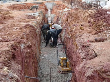 Kuala Lumpur, Malezya-02 Haziran 2017: yeraltı yardımcı programı ve Hizmetleri boru koydu işçiler inşaat sahasında siperlerde tarafından. Cork vanasını ve devam eden ortak kurulumu. 
