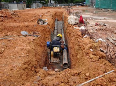 Kuala Lumpur, Malezya-02 Haziran 2017: yeraltı yardımcı programı ve Hizmetleri boru koydu işçiler inşaat sahasında siperlerde tarafından. Cork vanasını ve devam eden ortak kurulumu. 