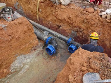 Kuala Lumpur, Malezya-02 Haziran 2017: yeraltı yardımcı programı ve Hizmetleri boru koydu işçiler inşaat sahasında siperlerde tarafından. Cork vanasını ve devam eden ortak kurulumu. 