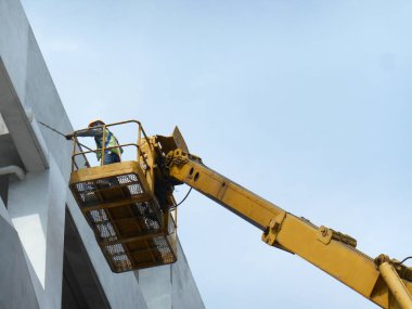Kuala Lumpur, Malezya-15 Haziran 2017: inşaat işçileri Mobil vinç ayakta kova inşaat alanı içinde yüksek düzeyde çalışırken. Kova hareket işçiler tarafından kendini kontrol.  