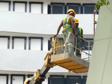 Kuala Lumpur, Malezya-15 Haziran 2017: inşaat işçileri Mobil vinç ayakta kova inşaat alanı içinde yüksek düzeyde çalışırken. Kova hareket işçiler tarafından kendini kontrol.  