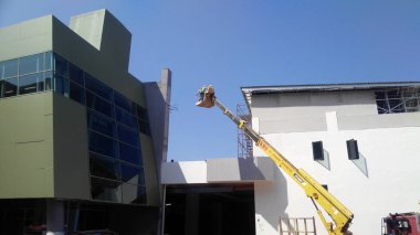 Kuala Lumpur, Malezya-15 Haziran 2017: inşaat işçileri Mobil vinç ayakta kova inşaat alanı içinde yüksek düzeyde çalışırken. Kova hareket işçiler tarafından kendini kontrol.  