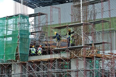 Kuala Lumpur, Malezya-10 Ağustos 2017: inşaat işçileri yükseklikte inşaat alanında çalışıyor. Onlar kötü olur etmelerini önlemek için uygun güvenlik dişli giymek için rica olunur. 