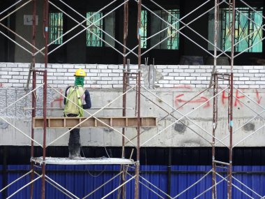 Kuala Lumpur, Malezya-10 Ağustos 2017: inşaat işçileri yükseklikte inşaat alanında çalışıyor. Onlar kötü olur etmelerini önlemek için uygun güvenlik dişli giymek için rica olunur. 