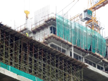 Kuala Lumpur, Malezya-10 Ağustos 2017: inşaat işçileri yükseklikte inşaat alanında çalışıyor. Onlar kötü olur etmelerini önlemek için uygun güvenlik dişli giymek için rica olunur. 