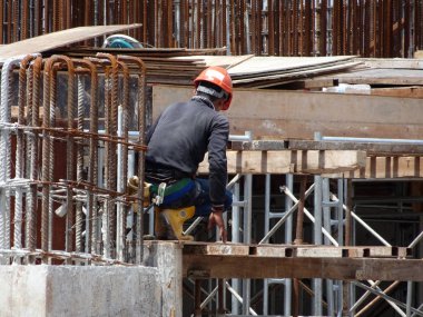 Kuala Lumpur, Malezya-10 Ağustos 2017: inşaat işçileri yükseklikte inşaat alanında çalışıyor. Onlar kötü olur etmelerini önlemek için uygun güvenlik dişli giymek için rica olunur. 