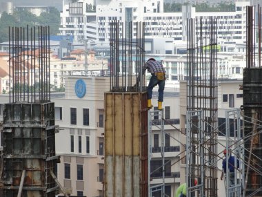 Kuala Lumpur, Malezya-10 Ağustos 2017: inşaat işçileri yükseklikte inşaat alanında çalışıyor. Onlar kötü olur etmelerini önlemek için uygun güvenlik dişli giymek için rica olunur. 