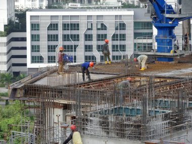 Kuala Lumpur, Malezya-10 Ağustos 2017: inşaat işçileri yükseklikte inşaat alanında çalışıyor. Onlar kötü olur etmelerini önlemek için uygun güvenlik dişli giymek için rica olunur. 