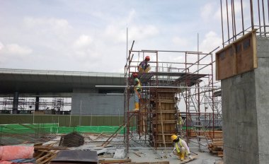 Kuala Lumpur, Malezya-10 Ağustos 2017: inşaat işçileri yükseklikte inşaat alanında çalışıyor. Onlar kötü olur etmelerini önlemek için uygun güvenlik dişli giymek için rica olunur. 
