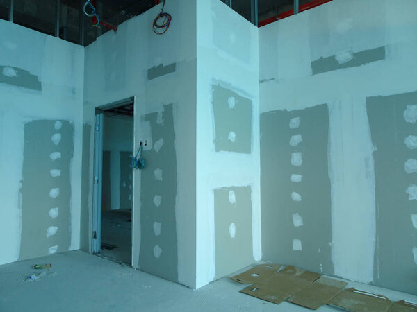 KUALA LUMPUR, MALAYSIA -MARCH 29, 2018: Drywall installation work in progress by construction workers at the construction site. It is the easiest and cheapest way to do partition for an interior wall. 