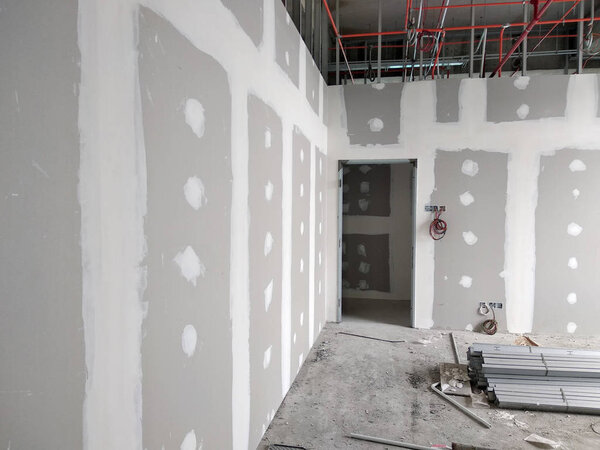 KUALA LUMPUR, MALAYSIA -MARCH 29, 2018: Drywall installation work in progress by construction workers at the construction site. It is the easiest and cheapest way to do partition for an interior wall. 