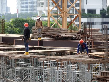 Kuala Lumpur, Malezya-10 Ağustos 2017: inşaat işçileri yükseklikte inşaat alanında çalışıyor. Onlar kötü olur etmelerini önlemek için uygun güvenlik dişli giymek için rica olunur. 