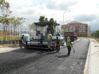 Kuala Lumpur, Malezya-15 Mayıs 2017: Premix iş inşaat işçileri tarafından. İşçiler tarafından tesviye ve kompaktör makine tarafından sıkıştırılmış asfalt katmanı. 