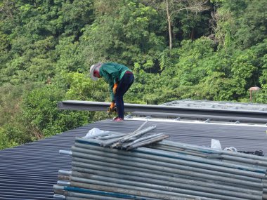 Kuala Lumpur, Malezya - 4 Temmuz 2018: İnşaat işçileri tarafından metal güverte çatı levha montajı. İle çatı yalıtımı ve ısı yansıtıcı sayfasını tamamlayın.